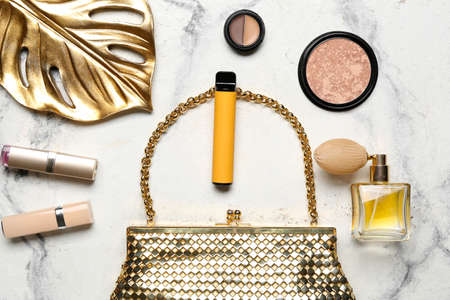 Disposable electronic cigarette, female bag and decorative cosmetics on light backgroundの写真素材