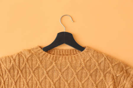 Hanger with knitted sweater on color background, closeupの写真素材