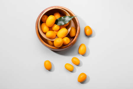 Bowl with tasty kumquat fruits on white backgroundの写真素材