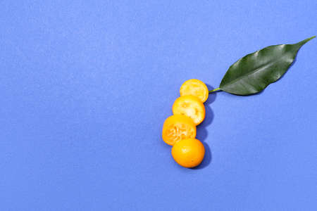 Cut tasty kumquat on blue backgroundの写真素材