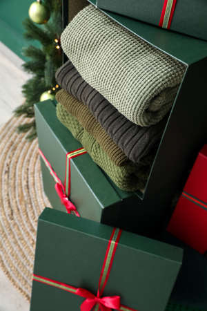 Gift boxes with winter sweaters in the room