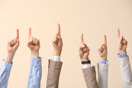 business people pointing at something on beige backgroundの写真素材