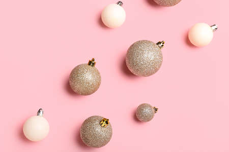 Different bright Christmas balls on pink background