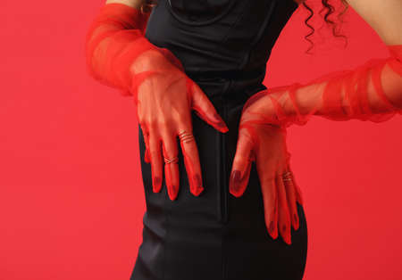Elegant young woman with stylish gloves on color background, closeupの写真素材
