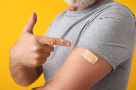 Mature man with applied nicotine patch on color background. smoking cessationの写真素材