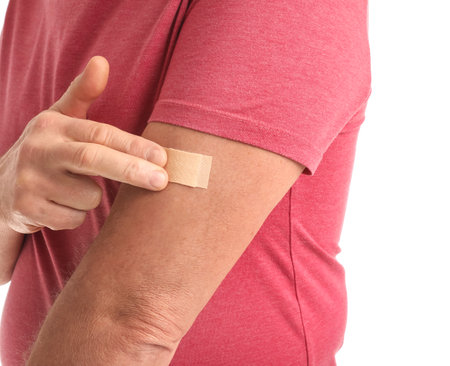 Mature man with applied nicotine patch on white background. smoking cessation