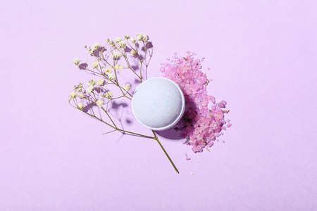 Bath bomb, sea salt and gypsophila flowers on lilac backgroundの写真素材