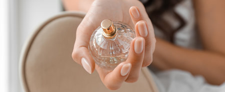 Beautiful young bride with bottle of perfume, closeup