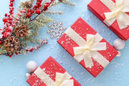 Composition with Christmas gift boxes, balls and fir branches on blue background
