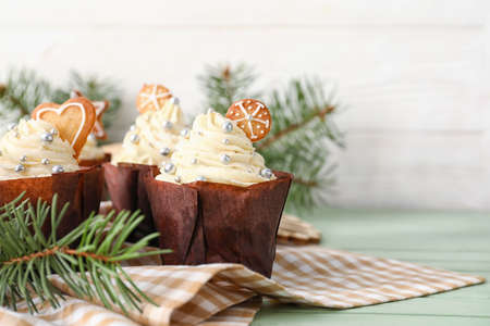 Delicious Christmas cupcakes with fir branches on tableの写真素材