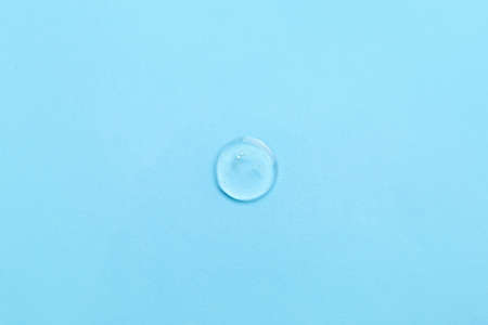 Drop of liquid transparent gel with bubbles on blue background