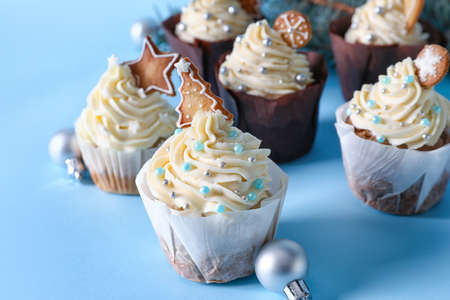 Delicious cupcakes and Christmas balls on blue backgroundの写真素材