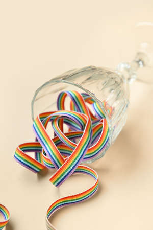 Glass with rainbow ribbon on color background. LGBT conceptの写真素材
