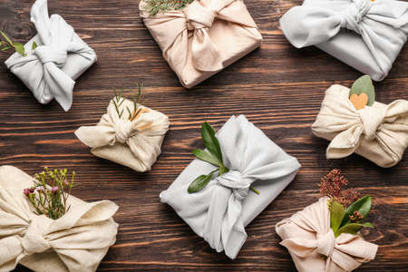 Many gift boxes wrapped in fabric on wooden backgroundの写真素材