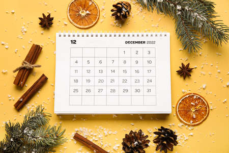 Calendar with date of winter solstice and decorations on color background