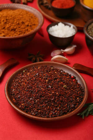 Bowls with different spices on red background, closeup