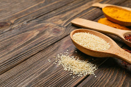 Spoon with sesame on wooden background, closeupの写真素材