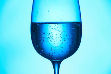 Glass of clear water on blue backgroundの写真素材
