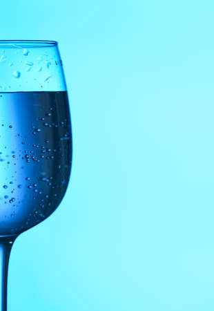 Glass of clear water on blue backgroundの写真素材