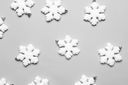 Beautiful Christmas decorations in shape of snowflakes on gray background