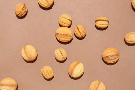 Many tasty walnut shaped cookies with boiled condensed milk on color backgroundの写真素材