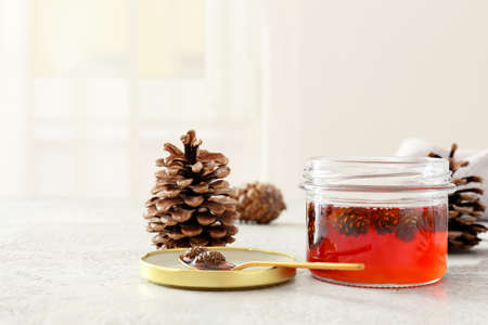 Jar of tasty pine cone jam on light backgroundの写真素材