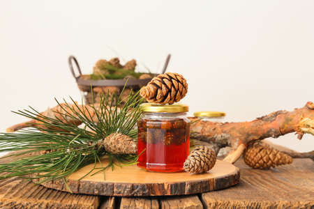 Jar of tasty pine cone jam on wooden table