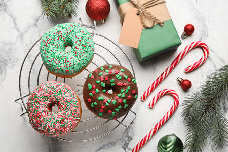 Grid with tasty Christmas donuts on light backgroundの写真素材