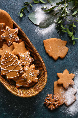 Basket with sweet Christmas gingerbread cookies on black background