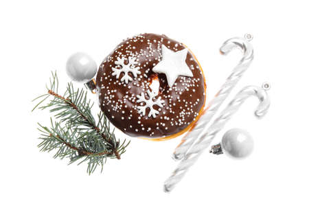 Tasty Christmas donut with fir tree branch, balls and candy canes on white backgroundの写真素材