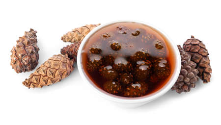 Bowl of tasty pine cone jam on white background