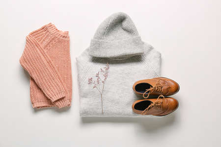 Warm children's clothes, shoes and flower branch on white backgroundの写真素材