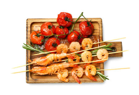 Wooden board with grilled shrimp skewers and tomatoes on white backgroundの写真素材