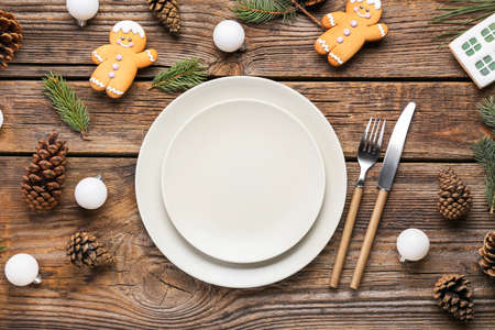 Beautiful table setting with pine cones, Christmas cookies and fir branches on wooden background