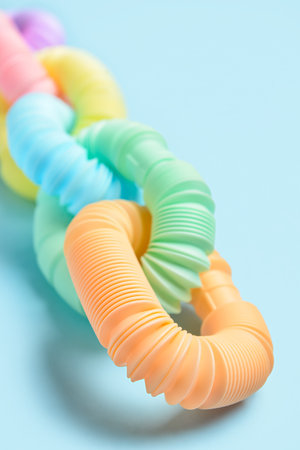 Different colorful Pop Tubes on blue background, closeup