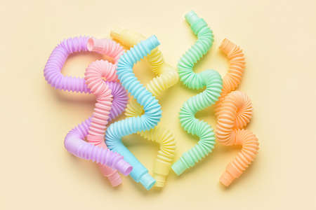 Different colorful Pop Tubes on beige background