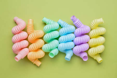 Different colorful Pop Tubes on green background