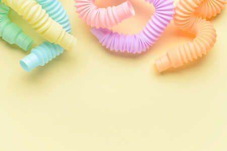 Different colorful Pop Tubes on beige background