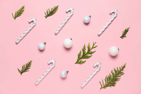 Composition with beautiful Christmas decorations and thuja branches on pink background