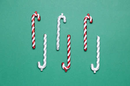 Christmas decorations in shape of candy canes on green background