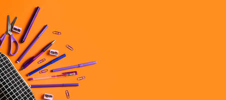 Pencil case and stationery on orange background with space for textの写真素材