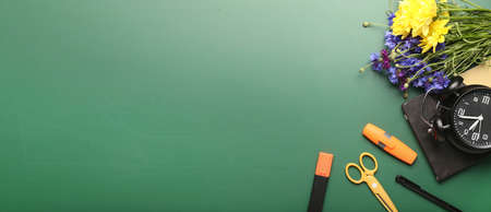 Beautiful flowers and school stationery on green background. teacher's day celebrationの写真素材