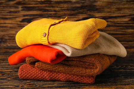 Stylish baby sweaters on wooden backgroundの写真素材