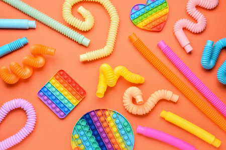 Colorful Pop Tubes and   fidget toys on orange backgroundの写真素材