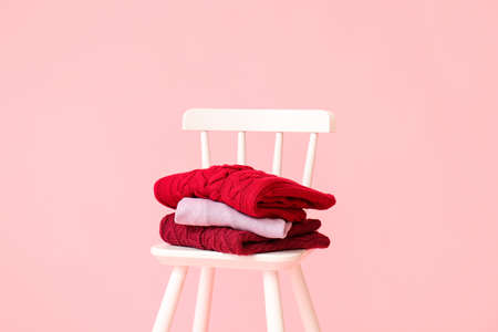 Chair with knitted sweaters on pink backgroundの写真素材