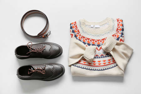 Male sweater, shoes and belt on light background