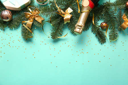 Beautiful Christmas composition with fir branches and bottle of champagne on green background