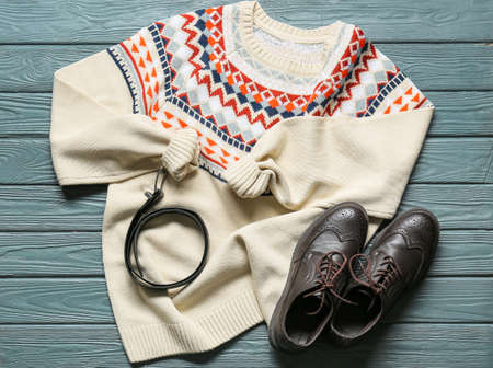 Male sweater, shoes and belt on color wooden backgroundの写真素材