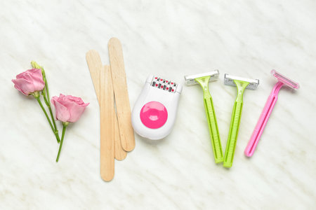 Different supplies for hair removal on light background