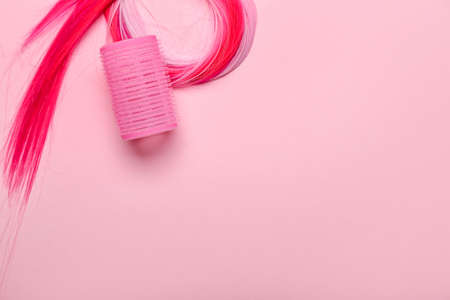 Colorful hair with curler on pink backgroundの写真素材